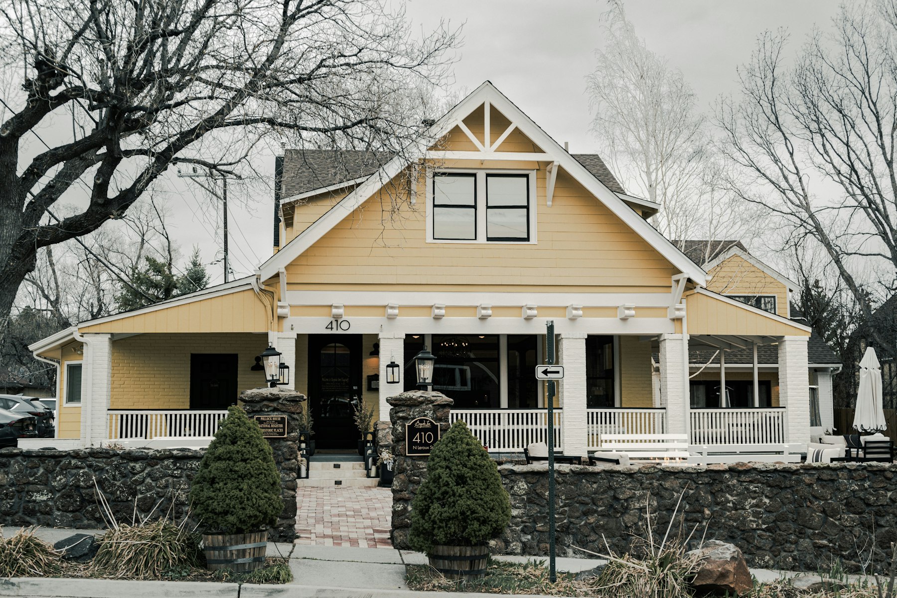 A yellow craftsman house with a deep covered front porch.