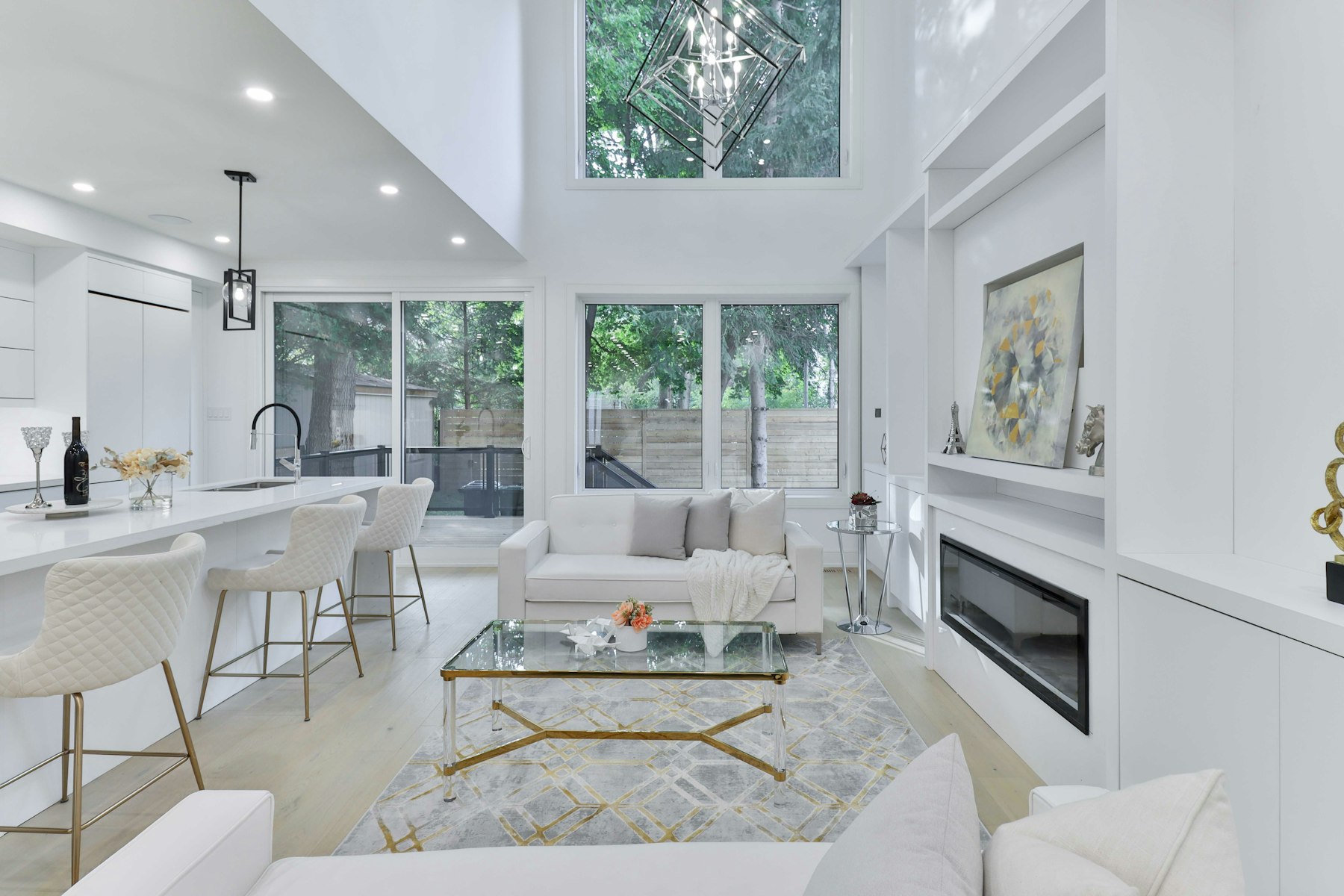 A bright white double-height living room with tall windows.