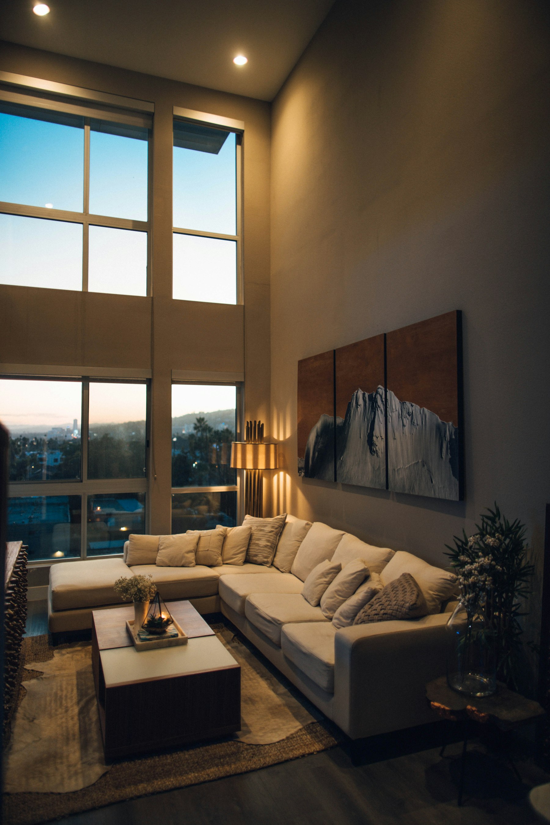 A Beckenbauer living room in the evening, one lamp lit beside the sofa.